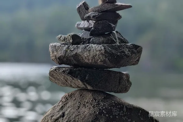高清摄影 湖边的平衡石堆和远处的山脉。