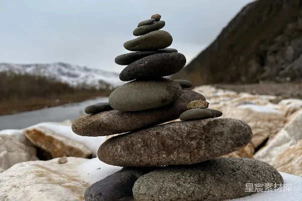 高清摄影 堆叠整齐的石头在雪岸上。
