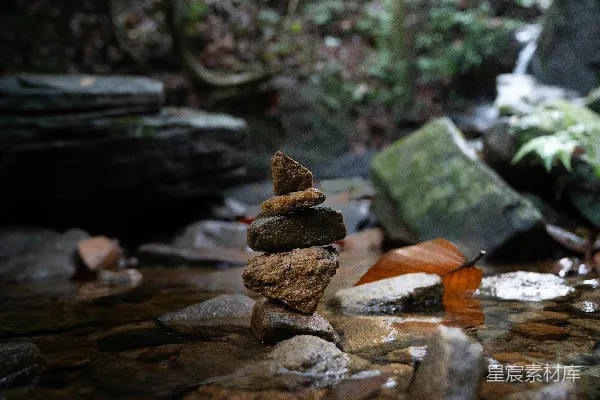 高清摄影 在自然溪流中，平衡的岩石堆成一个篝火堆。