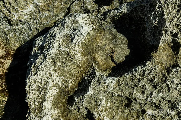 高清摄影 粗糙、纹理丰富的岩石表面，带有阴影和白色的矿物沉积物。