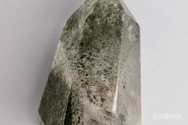 高清摄影 一个带有绿色包裹体的白色透明水晶尖端。