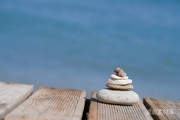 高清摄影 海边木板上的一堆平衡的石头。