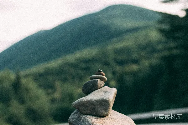 高清摄影 精心平衡的石堆，背景是宁静的山景。