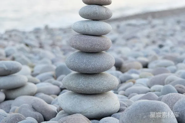 高清摄影 在鹅卵石海滩上堆叠的石头，背景是海洋。
