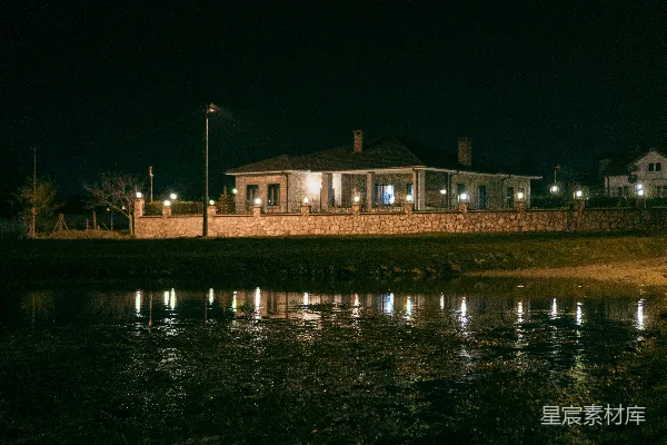 高清摄影 夜晚，一盏亮着的灯在黑暗的水中倒映。