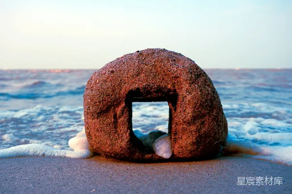 高清摄影 一块大石头坐落在沙滩上。