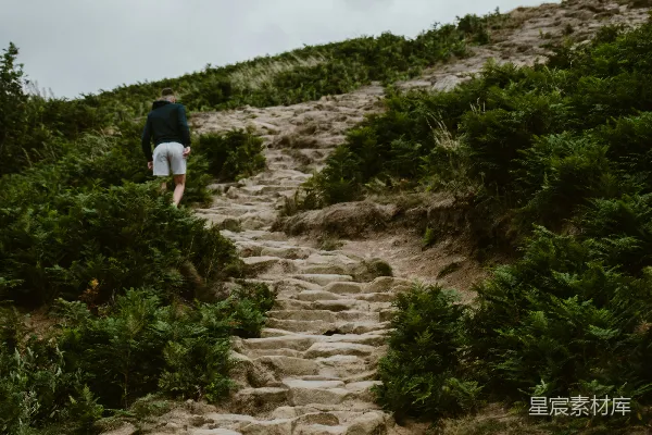 高清摄影 一个男人走在一条岩石小路上