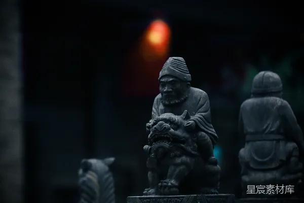高清摄影 一座男人抱着狗的雕像，矗立在其他雕像前面。