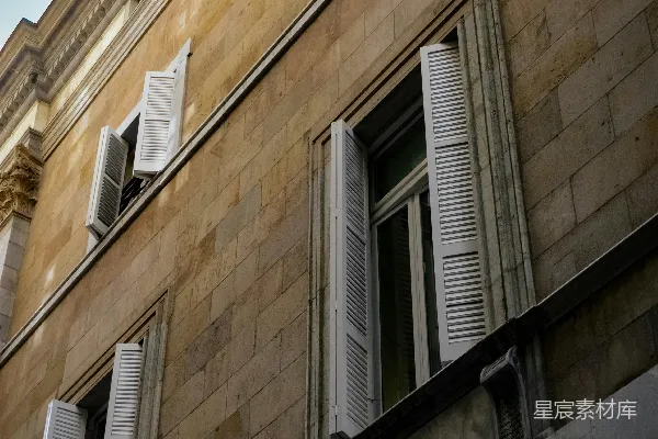 高清摄影 石头建筑外墙，窗户上有打开的白色百叶窗