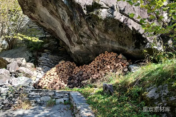 高清摄影 一座巨大的岩石坐落在郁郁葱葱的山坡上。