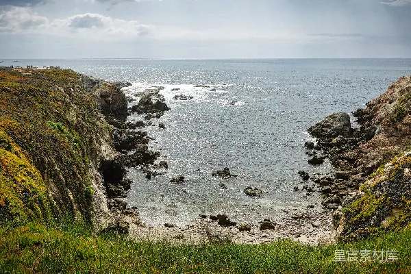 高清摄影 一个岩石海滩，海浪拍打着岩石。
