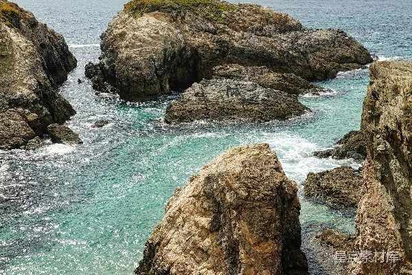 高清摄影 一座岩石海滩，背景中有一片水域。
