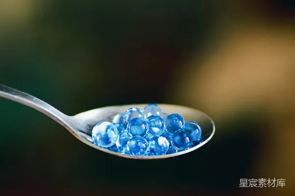 高清摄影 一个装满蓝色珠子的勺子放在桌子上。