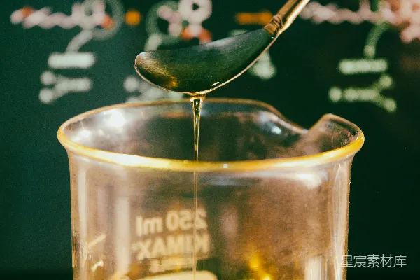 高清摄影 一杯液体上面有一片绿色的叶子。