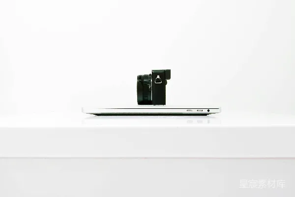 高清摄影 一部无反光镜相机放在 MacBook 上