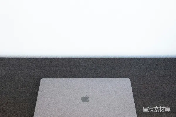 高清摄影 银色的MacBook放在棕色的木桌上。