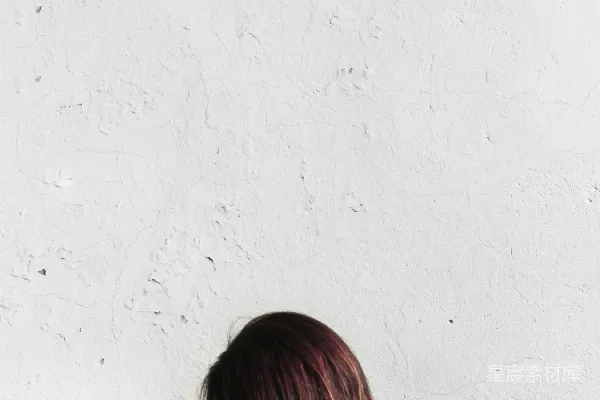 高清摄影 白天，一个穿着白衬衫的女人靠在墙上。