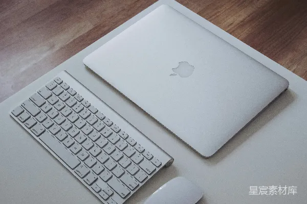 高清摄影 银色的MacBook靠近Apple Magic Keyboard和Apple Magic Mouse，放在白色表面上。