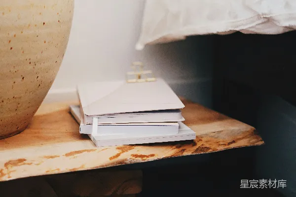 高清摄影 一堆书靠近一个陶瓷花瓶。