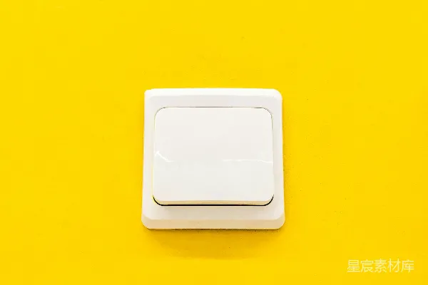 高清摄影 一个白色的开关放在黄色的墙上。