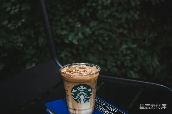 高清摄影 星巴克的塑料杯在蓝色书本上