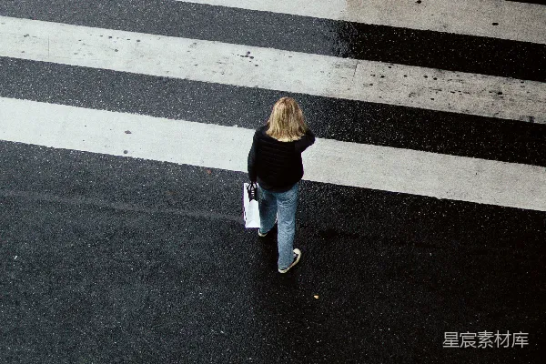 高清摄影 穿着棕色夹克和白色裤子的女人在人行道上行走