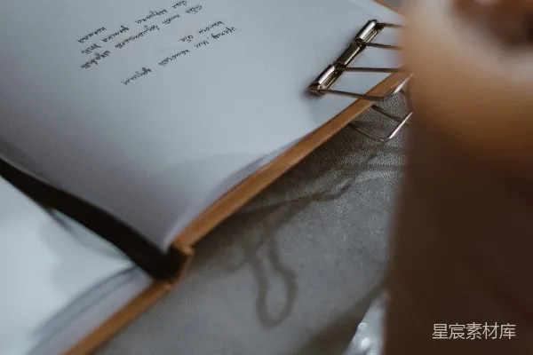 高清摄影 一只手拿着一支笔和一张纸，纸上有一张便签。