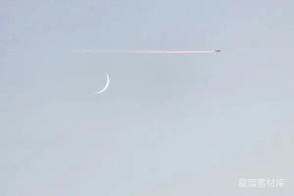 高清摄影 一架飞在天空中的飞机，月亮只有一半。