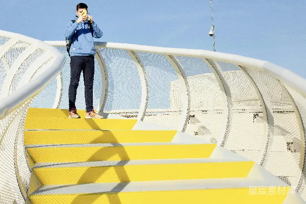 高清摄影 一个男人站在黄色楼梯的顶部