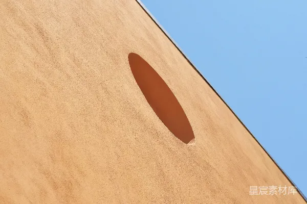 高清摄影 一座建筑物，其侧面有一个圆形的洞。
