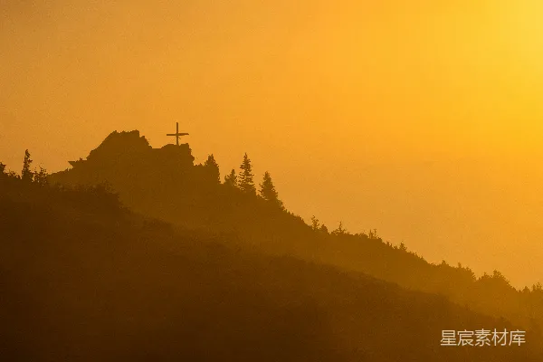 高清摄影 太阳正落在这座山丘之上，山上有一座教堂。