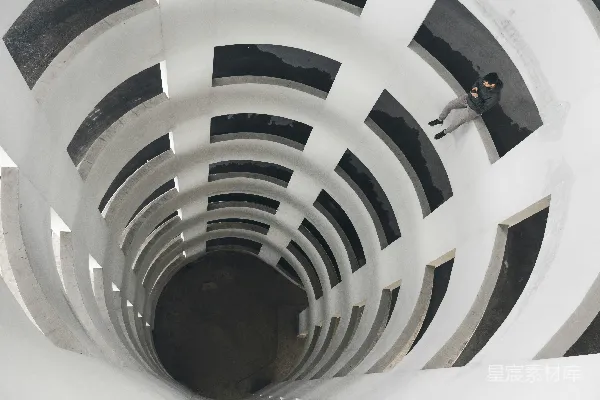 高清摄影 一个男人坐在建筑物边缘，面朝下。