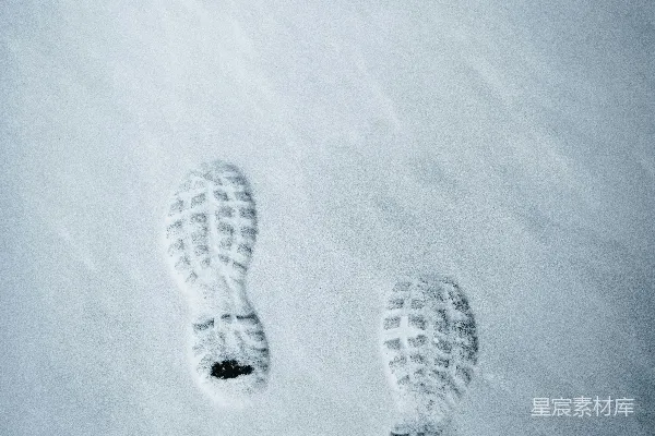 高清摄影 阳光明媚的日子里，雪地上有一对脚印。