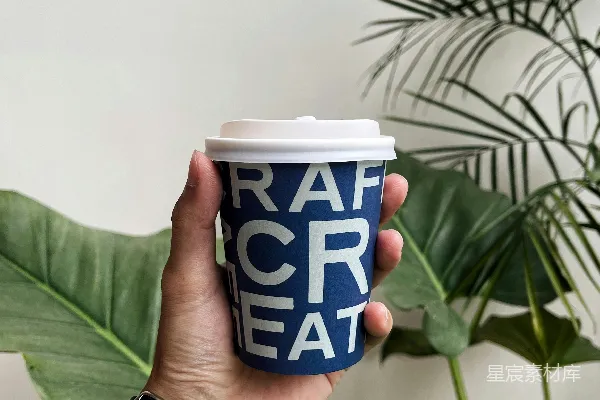 高清摄影 一只手拿着一个咖啡杯，咖啡杯上写着“Rah Creat”。