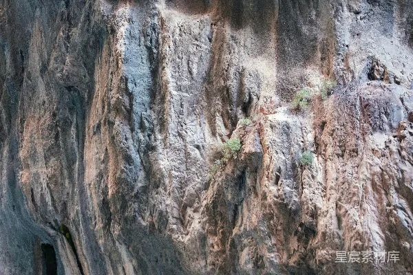 高清摄影 一座山脚下长着岩石和植物的山边