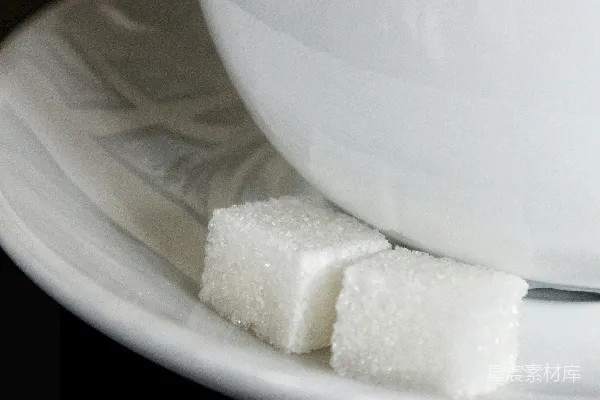 高清摄影 一个白色的糖立方体放在一个白色的陶瓷盘子上。