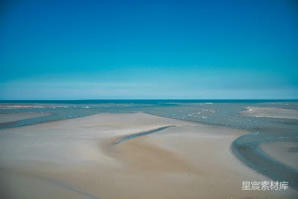 高清摄影 一片广阔的沙地，背景是蓝天。