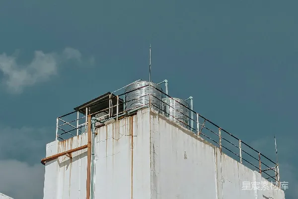 高清摄影 一座白色建筑，带有水箱，背景是多云的天空。