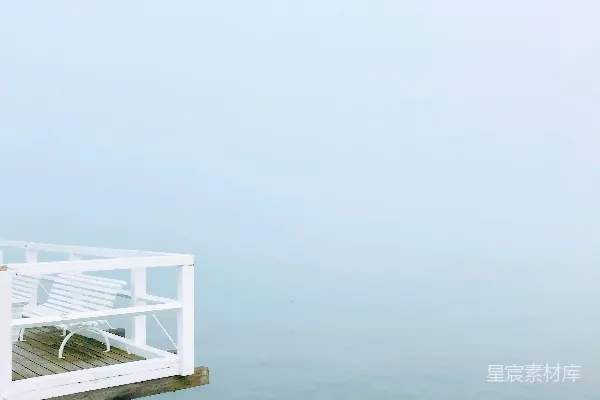 高清摄影 一个白色的长凳放在一个木制码头的顶部。
