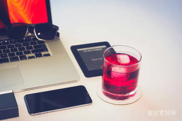 高清摄影 MacBook Pro旁边有一个透明玻璃杯。