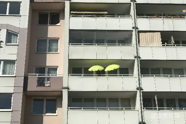 高清摄影 两把黄色雨伞摆放在公寓楼的阳台上。