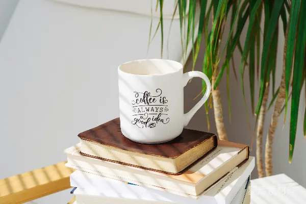高清摄影 白瓷杯放在棕色木桌上