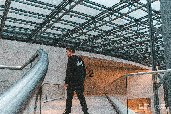 高清摄影 穿着黑白夹克的男子正在建筑物内行走。