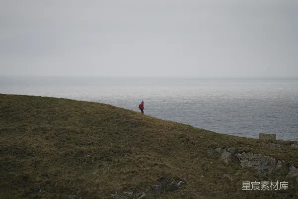 高清摄影 站在海边山坡顶上的人