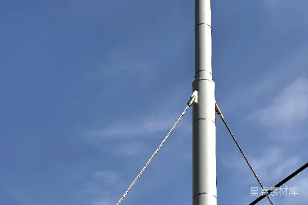高清摄影 一杆高高的白色柱子立在建筑物旁边。