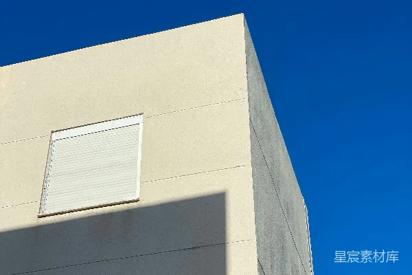 高清摄影 一座白色的建筑，旁边有一扇窗户，背景是天空。