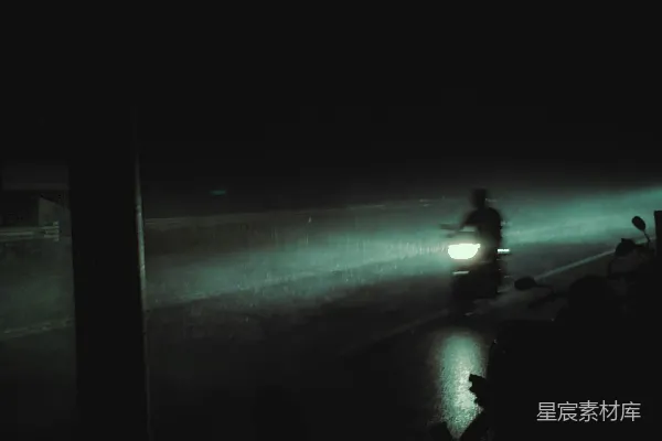 高清摄影 一张模糊的照片，显示一个人在夜晚的海滩上行走。