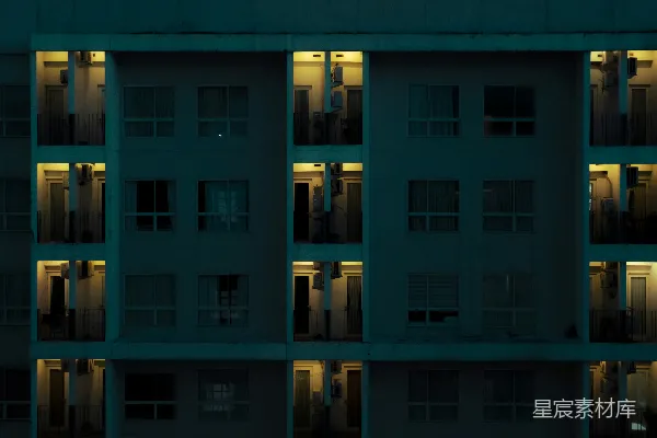高清摄影 在夜晚，一栋公寓楼的窗户亮着灯。
