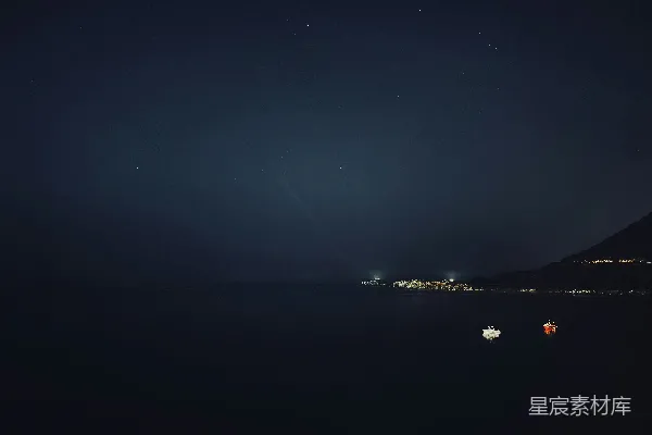 高清摄影 夜晚，远处的灯光在黑暗的海洋上闪烁。