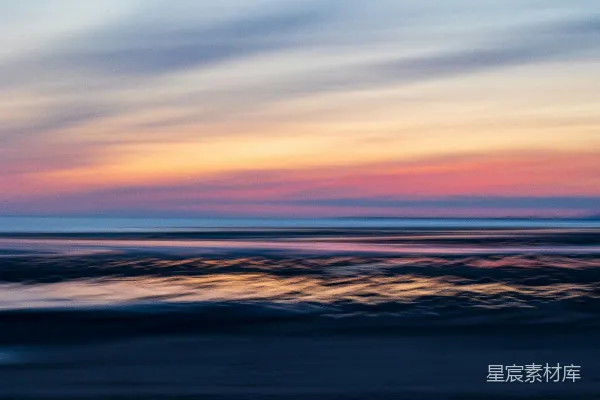 高清摄影 一张模糊的海景照片，夕阳在海平面上投下柔和的余晖。